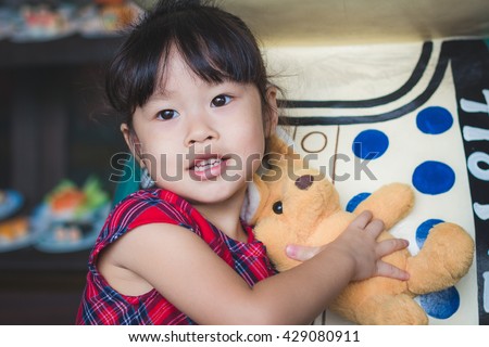 Asian baby cute girl with curly hair hug kangaroo doll