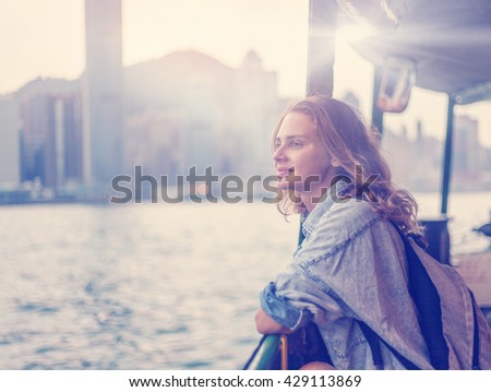 girl tourist on background of a big city with skyscrapers, looking at the sunset