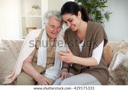 Grandma and granddaughter taking a picture over a smartphone