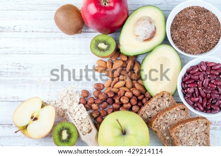 Avocado, flax seeds, whole grain bread, kiwi fruit, nuts, oatmeal, beans and apples on wooden boards. Healthy food. Top view Royalty-Free Stock Photo #429214114