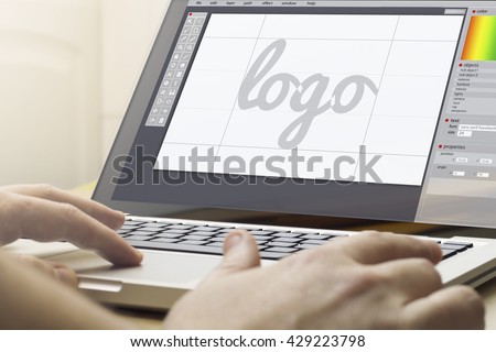 logo design concept: man using a laptop with logo design software on the screen. Screen graphics are made up.