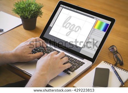 graphic design concept. Close-up top view of a graphic designer designing a logo on laptop. all screen graphics are made up.