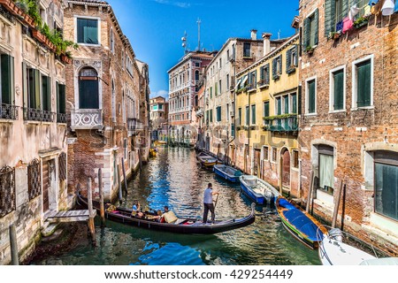 Gondola on a water canal in Venice, Italy surrounded by beautiful old buildings Royalty-Free Stock Photo #429254449
