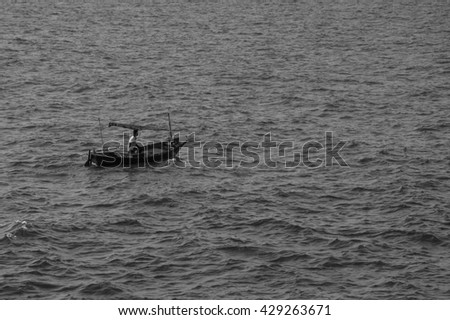 pattern of the vast sea with a fisherman boat sailing in motion blur (black and white picture)