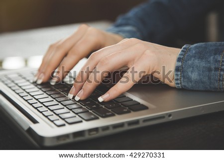 Cropped image of woman typing on laptop
