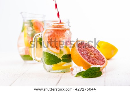 Summer detox drink with fresh fruits in glass jar.