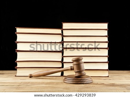 books and wooden gavel on black background
