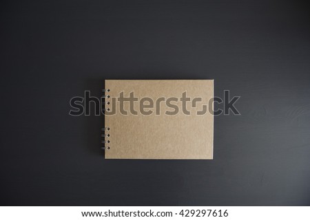 Paper notebook made from craft paper, on the dark wooden table background, minimalism