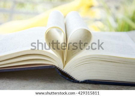 Heart from a book page, vintage style, close up heart shape from paper book with soft light in morning (blur background), concept for valentine's day