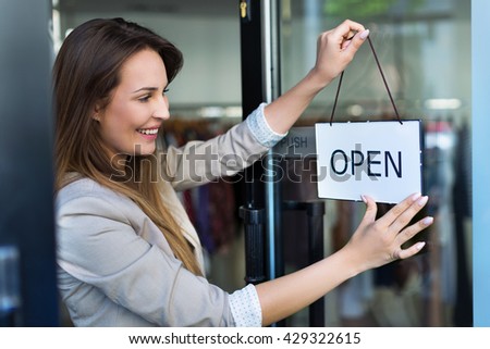 Woman hanging open sign on door

