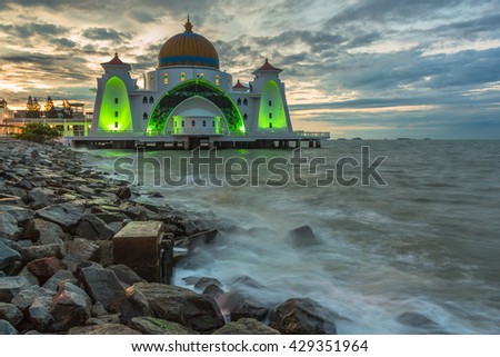 MAGNIFICENT STRAIT MOSQUE OF MALACCA. THE SHOT TAKEN AT SUNRISE COMPLIMENTED WITH THE  LIGHT  AND THE LONG EXPOSURE OF THE WAVES.