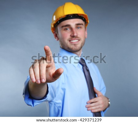 Man in helmet making sign with hand on grey background