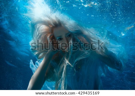 Woman with long blonde hair under the water, it looks like a mermaid. Royalty-Free Stock Photo #429435169
