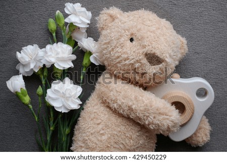 Teddy bear with wood toy camera and flower.