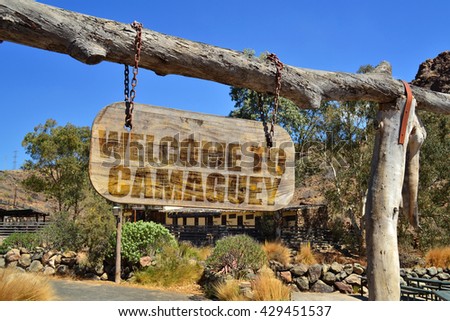old vintage wood signboard with text " welcome to Camaguey" hanging on a branch