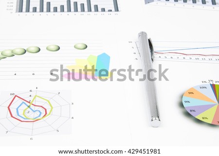 Business still-life of shiny pen, sticker, bookmarks, graphs