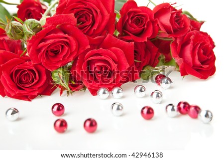 Red roses bouquet and beads on white background