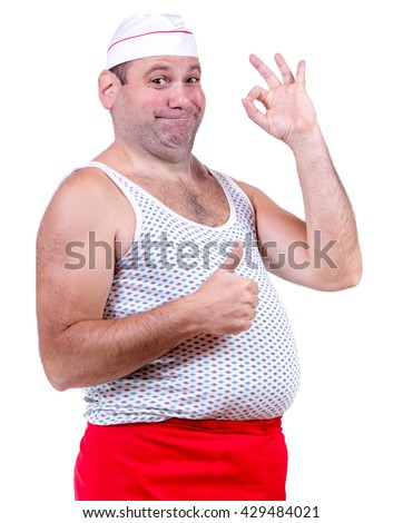 Cook in undershirt gesturing success on white background. The friendly chef shows perfect gesture for success. Fat chef with hat gesturing O.K. on white background. Simpleton cook gesturing thumb up. Royalty-Free Stock Photo #429484021