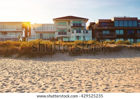 Front view of house on the beach and a setting sun, real estate with space for text Royalty-Free Stock Photo #429525235