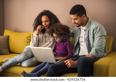 African american family watching cartoons on a laptop.