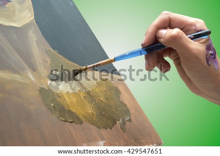 artist paints picture on canvas