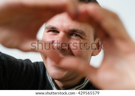 man making a hand heart frame