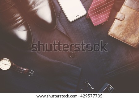 Men's wallet, watch, tie and shoes on suit