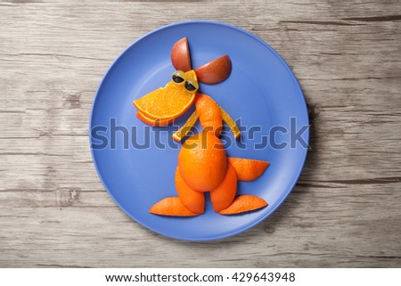 Kangaroo made of orange on plate and wood