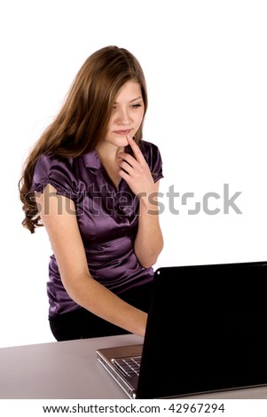 A business woman working on her laptop thinking about what is happening.