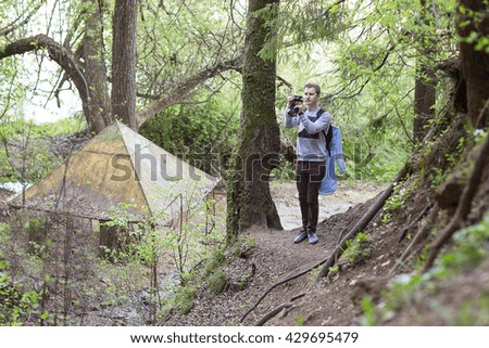 man with a backpack photographed on a photocamera natural landscape