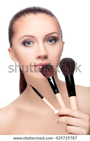 Beauty woman with Makeup Brushes. Natural Make-up for Brunette girl with Blue Eyes. Beautiful Face. Makeover. Perfect Skin. Applying Makeup