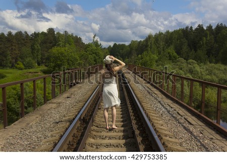 girl in white dress on the railroad