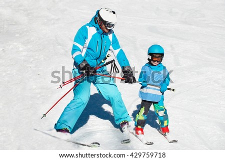 Ski school - little boy skiing with instructor