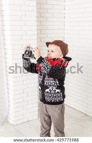 little boy in a cap and scarf photographs
