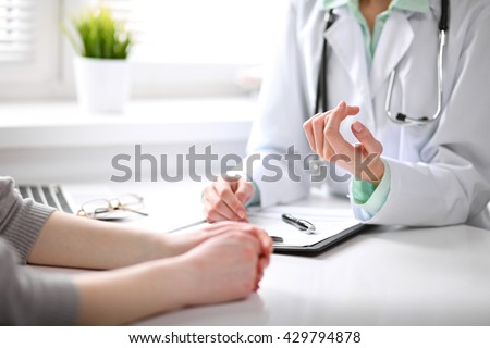 Close up of doctor and  patient  sitting at the desk near the window in hospital Royalty-Free Stock Photo #429794878