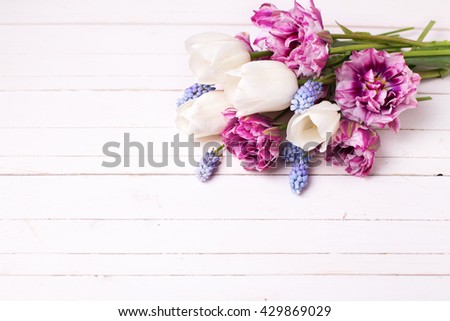 Fresh spring flowers on white wooden table. Floral still life. Selective focus. Place for text.