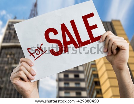 For Sale placard with cityscape background