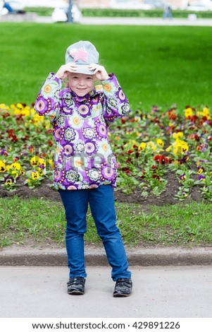 The girl in the Park standing near the flowers
