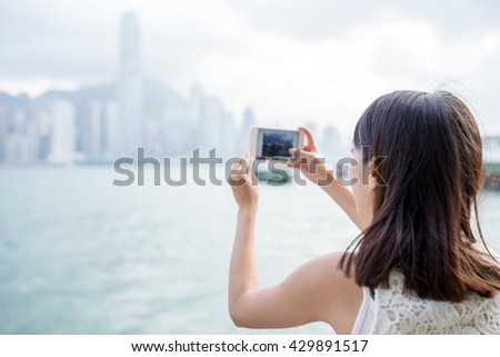 Woman taking photo of the skyline in Hong Kong