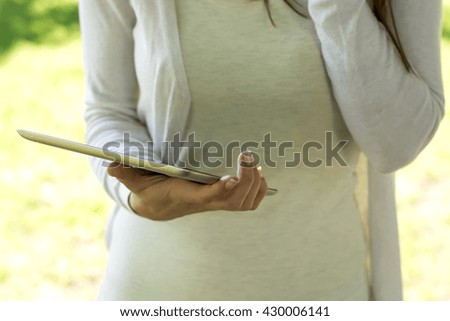 A cropped image of a businesswoman working on a digital tablet
