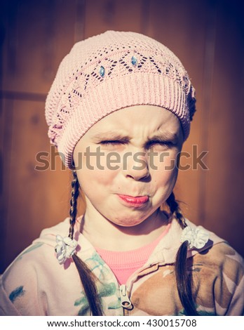 Close-up portrait of sad little girl with pursed lips.