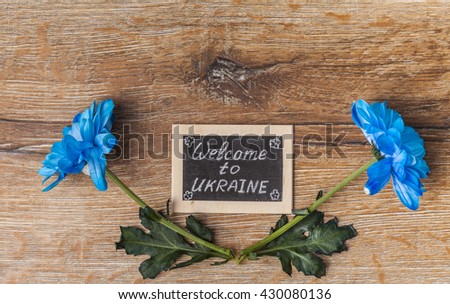 bouquet of flowers and card  on the old wooden background. Welcome to Ukraine