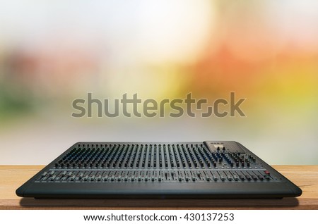 Mixer music, mixer board, mixer on desk with blurred light background.