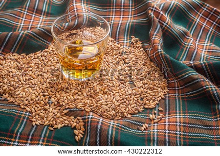 Glass of Scotch whisky on a tartan Royalty-Free Stock Photo #430222312