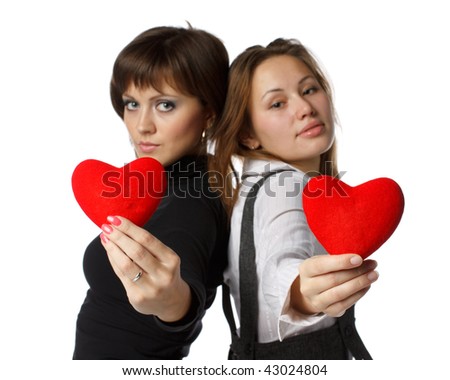 Two beautiful girls holds in hands a red heart on a white background.
