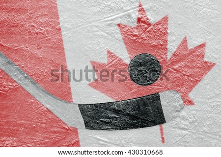 Hockey puck, hockey stick and Canadian flag image on ice