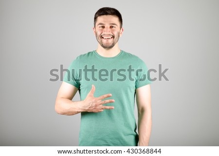 Handsome man counting to four isolated on a gray background