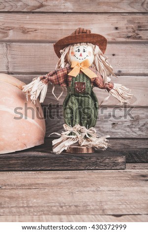 scarecrow and pumpkin on a wooden background
