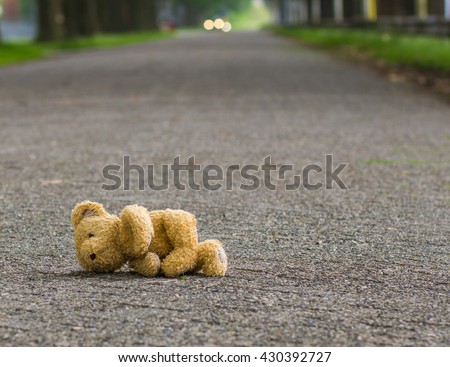 Lost teddy bear lying alone on the road Royalty-Free Stock Photo #430392727