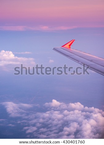 Shot of airplane wing see the clouds blue sky before sunset